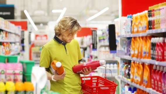 personne regardant l'&eacute;tiquette d'un produit nettoyant