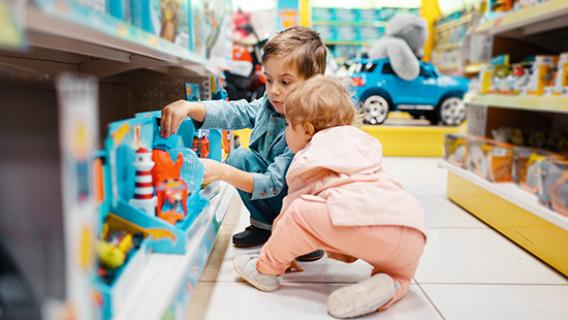 Deux enfants dans un rayon de jouets de supermarch&eacute;