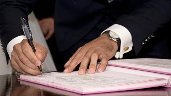 Une personne en train de sign&eacute; un document