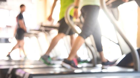 Des sportifs s'entraînent sur des tapis de course dans une salle de sport