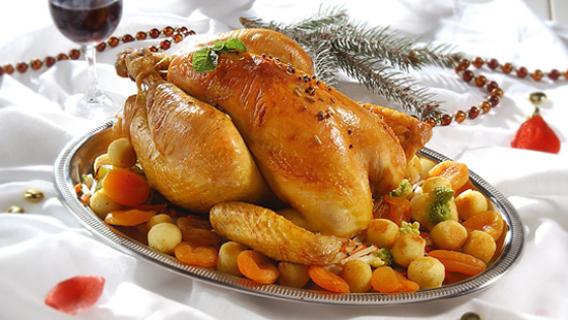 Une dinde posée sur un plat avec une garniture.