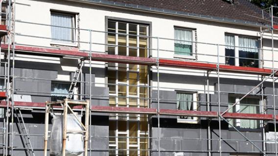 Un immeuble en travaux est caché par un échaffaudage.