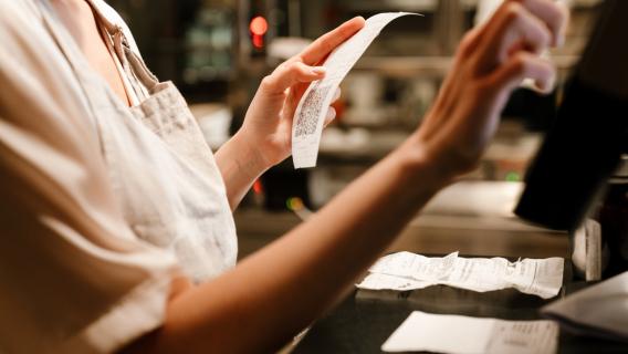 Hôtesse de caisse saisissant des factures sur son ordinateur