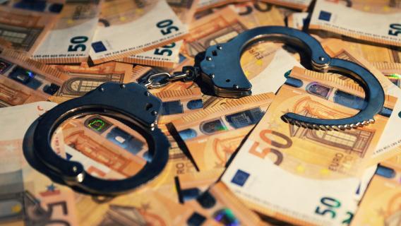 billets de 50€ et menottes de police