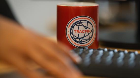 Tasse avec logo TRACFIN sur un bureau