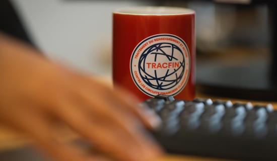 Tasse avec logo TRACFIN sur un bureau