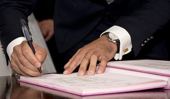 Une personne en train de sign&eacute; un document