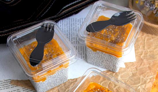 Un plateau d&eacute;jeuner pr&eacute;sente deux contenants avec fourchettes en plastique