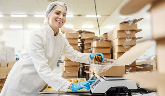 employée industrielle pesant des biscuits préemballés