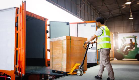 personne chargeant un camion de transport de marchandises