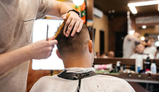 Homme se faisait couper les cheveux dans un salon de coiffure.