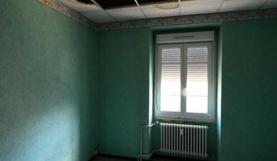 Pièce avec débris au sol et plafond ouvert 