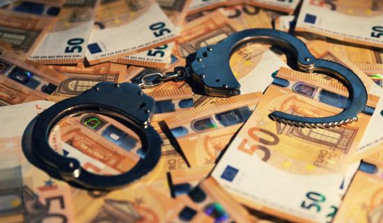 billets de 50€ et menottes de police